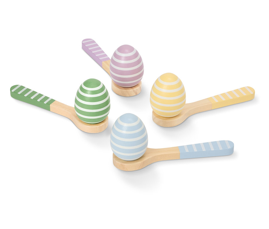 Vier bemalte, gestreifte Ostereier in Pastellfarben liegen auf kleinen Holzlöffeln.