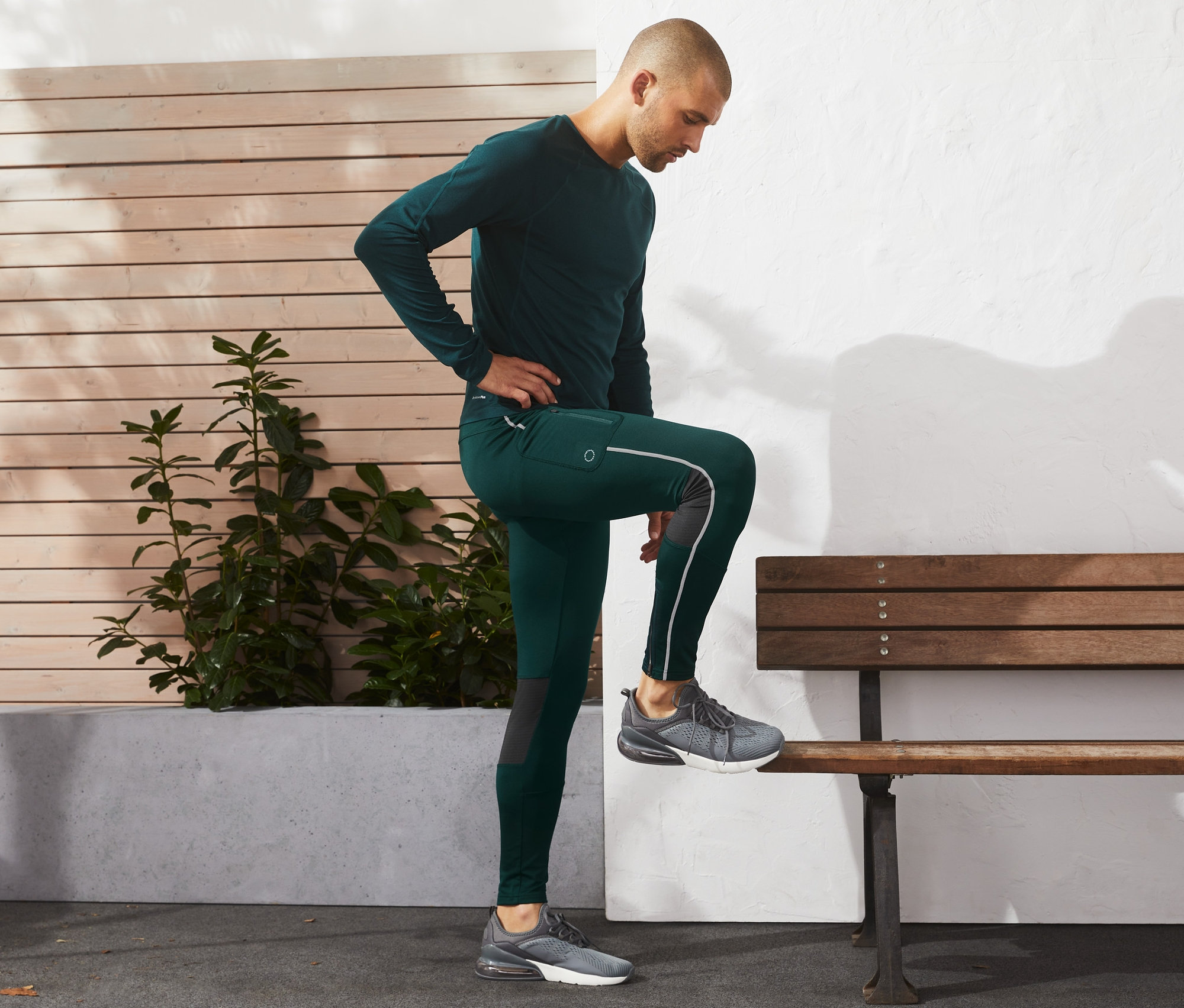 Mann in Thermo-Tight stellt Bein auf Bank.