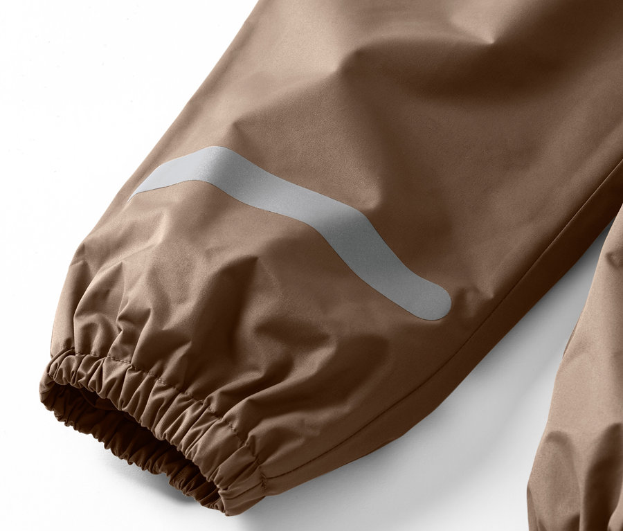 Detailaufnahme einer Kinder-Regenhose mit Reflexstreifen am Hosenbein.