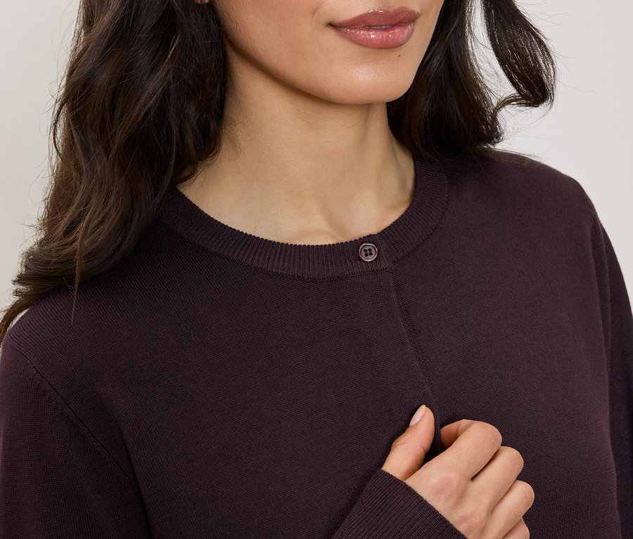 Oberkörper einer Frau in einem kastanienbraunen Cardigan mit Rundhalsausschnitt und einem Knopf.