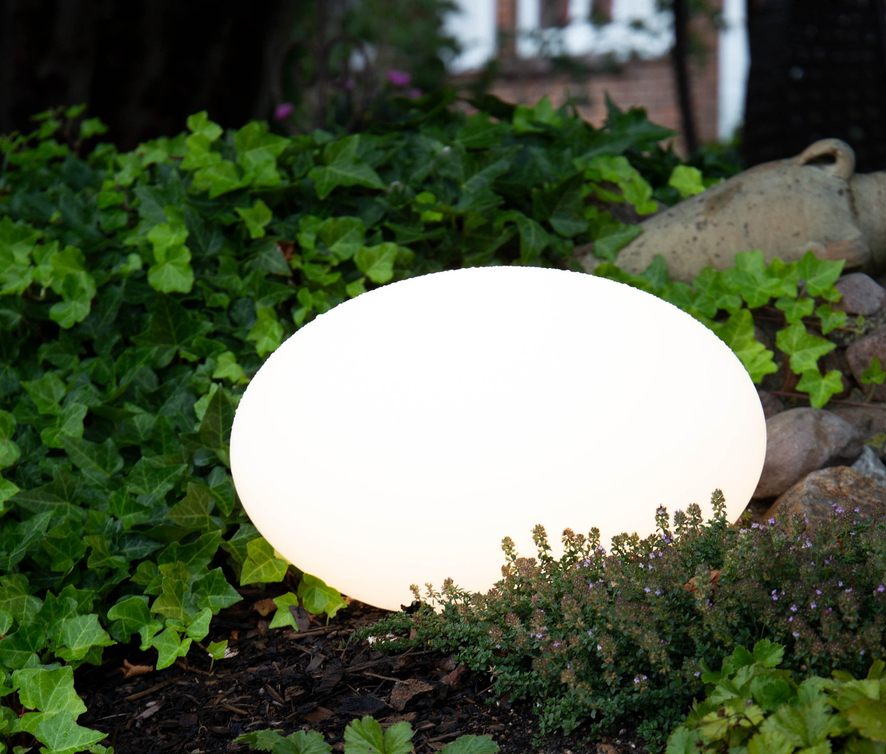 Eine leuchtende 8 seasons design LED-Leuchte inmitten von Grün.