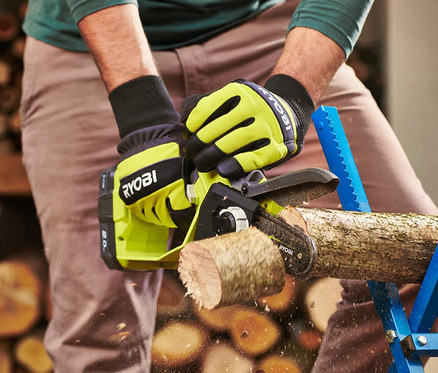 Mann sägt einen Ast mit einer RYOBI 18 V One+ Brushless Akku-Einhand-Kettensäge.