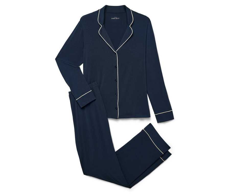 Marineblauer Pyjama mit langärmeligem Oberteil und Hose mit weißer Paspelierung auf weißem Hintergrund.