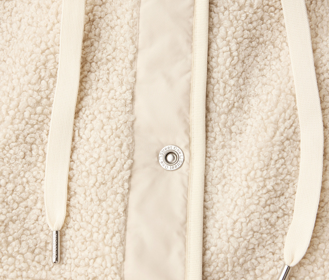 Detailansicht einer Street One Teddyjacke mit abnehmbarer Kapuze in Beige, mit Kordelzug und Knöpfen.