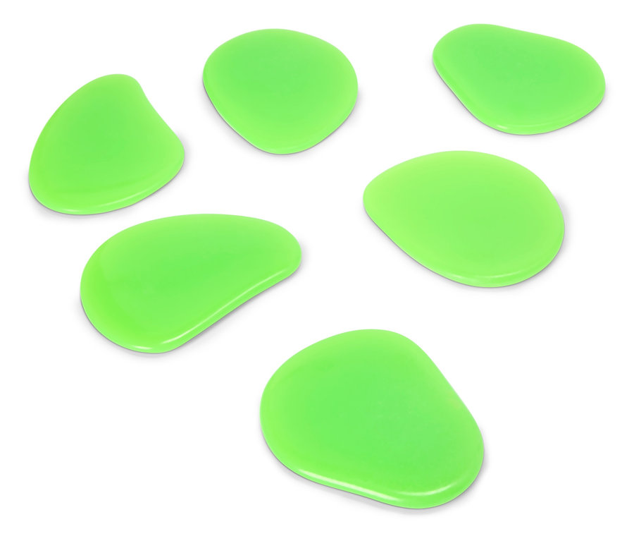 Sieben grüne, unregelmäßig geformte Steine liegen auf einer weißen Oberfläche.