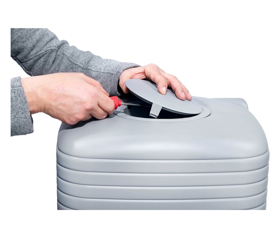 Eine Person öffnet mit einem Schraubenzieher einen grauen Abfalleimer.