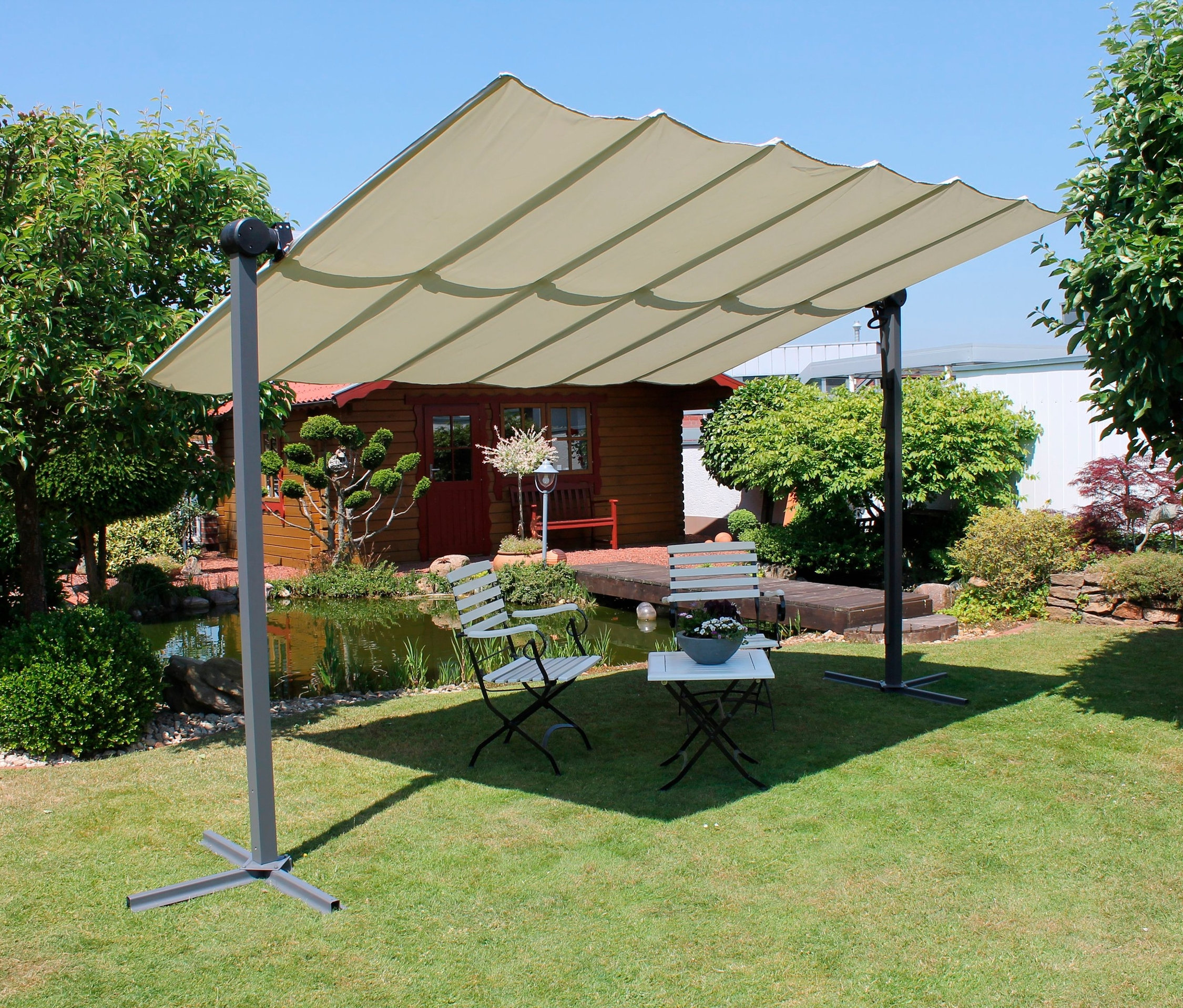 Garten mit Teich und Sitzgelegenheit unter hellem Leco Sonnendach, 400 x 250 cm.