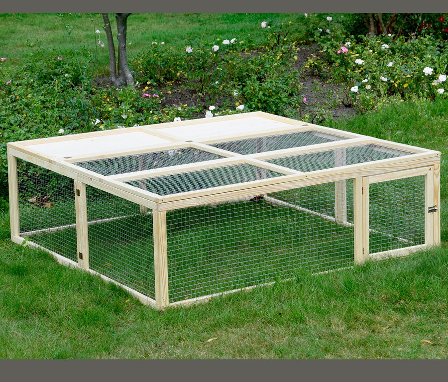 Ein rechteckiges, hölzernes Dobar Freilaufgehege auf einer Rasenfläche.