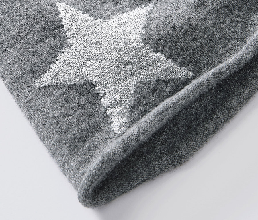 Detailansicht einer grauen Feinstrick-Beanie mit Glitzer-Stern.