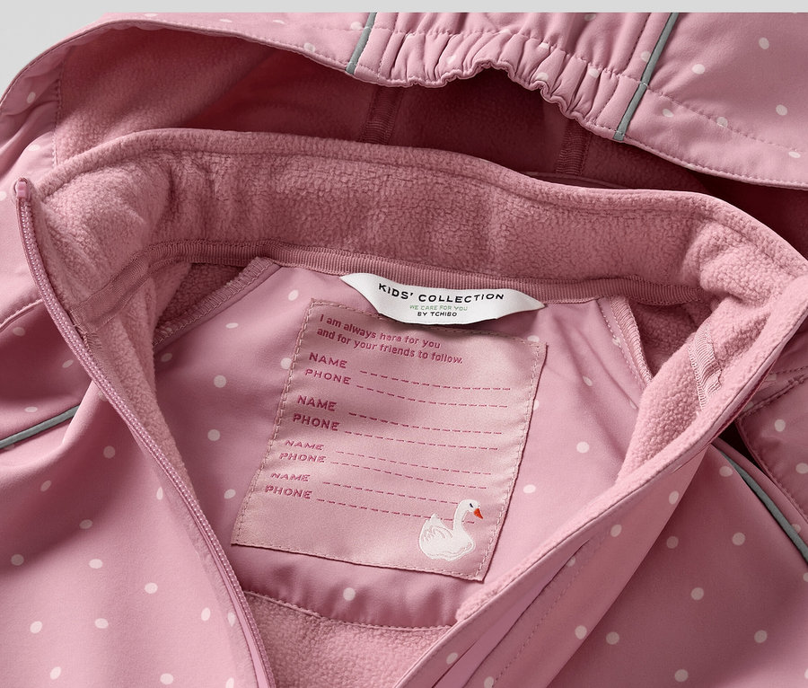 Detailansicht eines rosa Kinder-Softshell-Einteilers mit weißen Punkten.