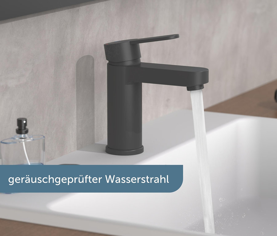 Wasser fließt aus der schwarzen Schütte-Waschtischarmatur »Elephant« in ein weißes Waschbecken.