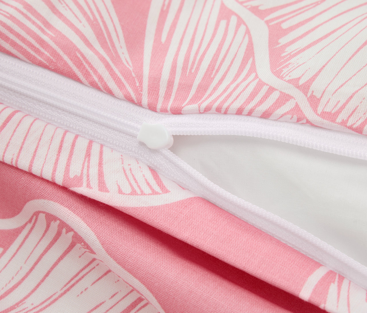 Detailansicht eines Baumwollbettbezugs mit Blumenmuster und teilweise geöffnetem Reißverschluss.