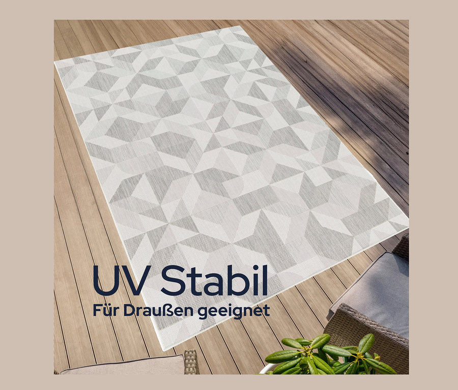 Ein faltbarer Outdoor-Teppich im Mosaik-Design liegt auf einer Holzterrasse.