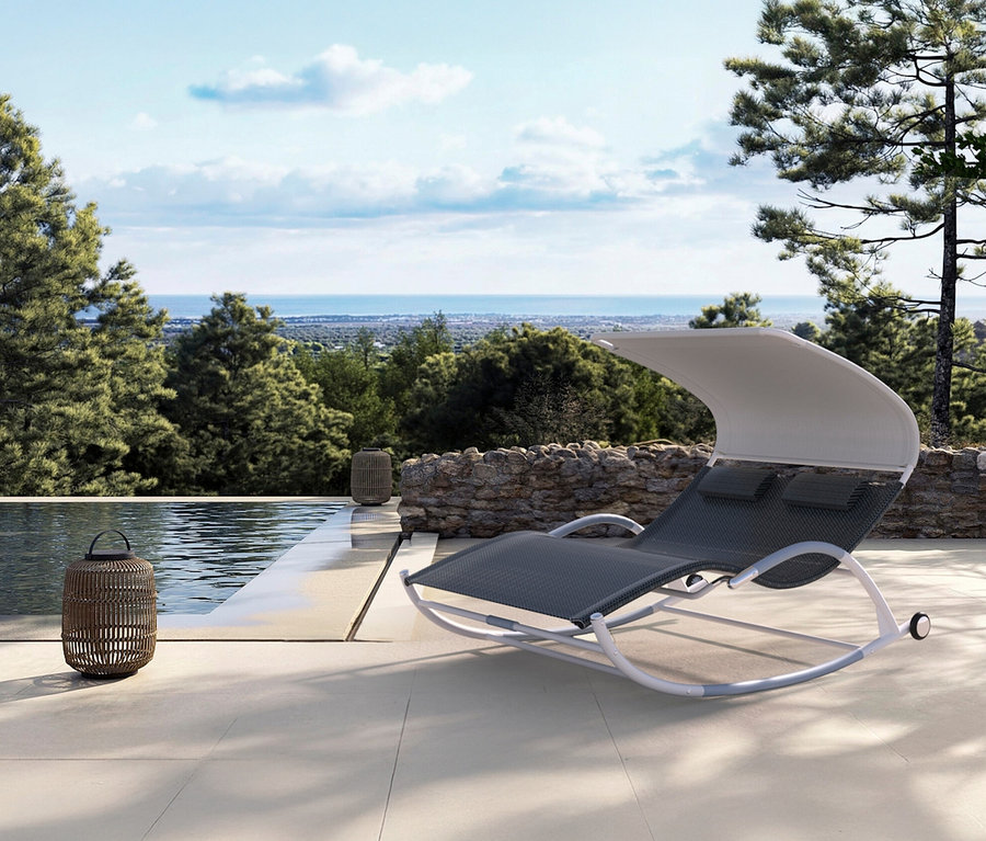 Ein grauer Schaukelstuhl mit weißem Rahmen und Überdachung steht auf einer Terrasse neben einem Pool.