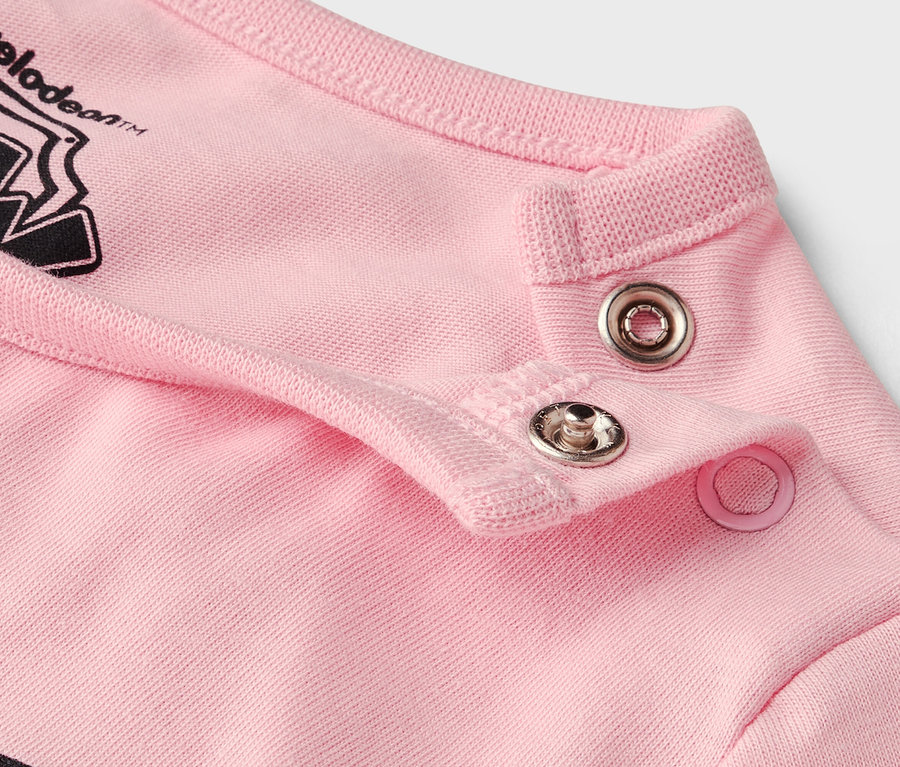 Nahaufnahme von Druckknöpfen an einem rosafarbenen Kleidungsstück.
