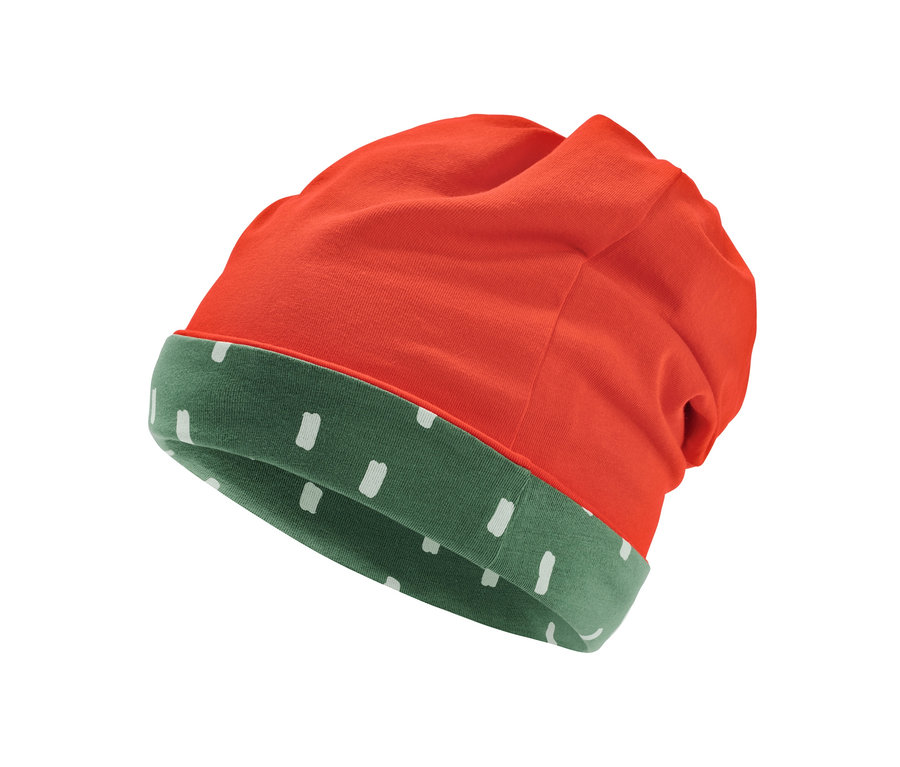 Detail einer Wendemütze, orange außen und grün mit weißen Punkten innen.