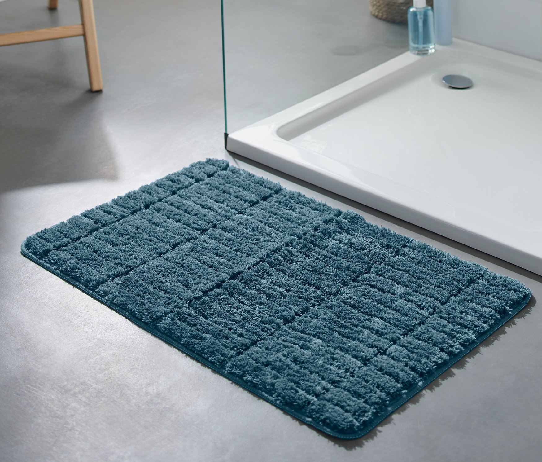 Im Badezimmer liegt eine blaue Comfort-Badematte, ca. 50 x 80 cm.