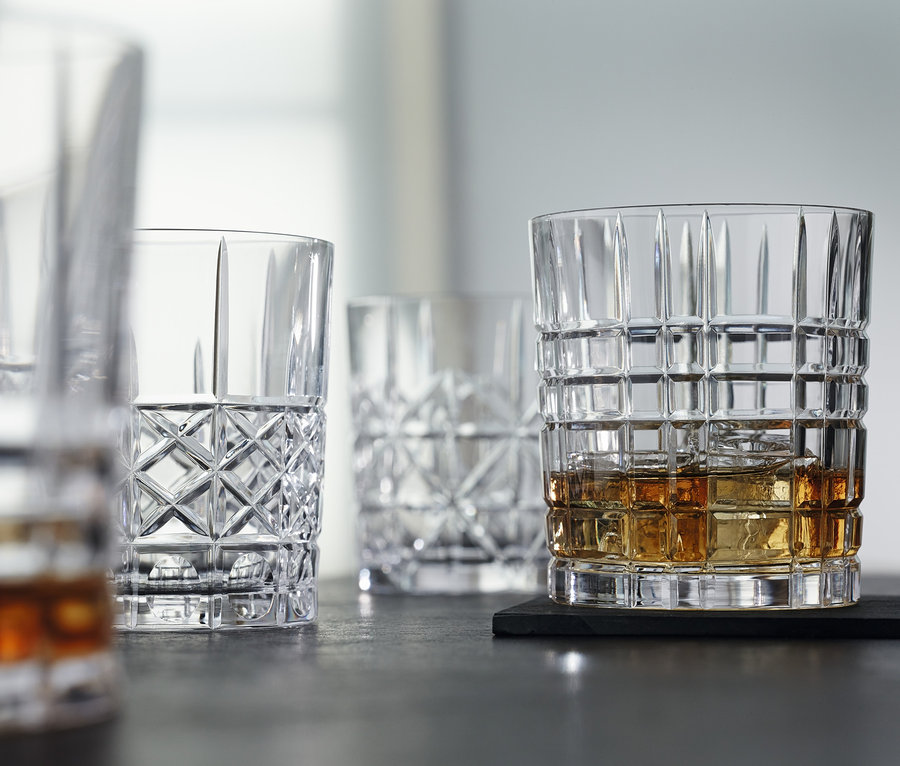 Vier Nachtmann Tumbler »Highland« auf dunkler Fläche, einer mit Eis und Flüssigkeit.