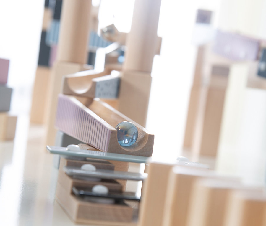 Detailaufnahme einer hölzernen roba Kugelbahn, 100-teilig, mit einer Glaskugel.