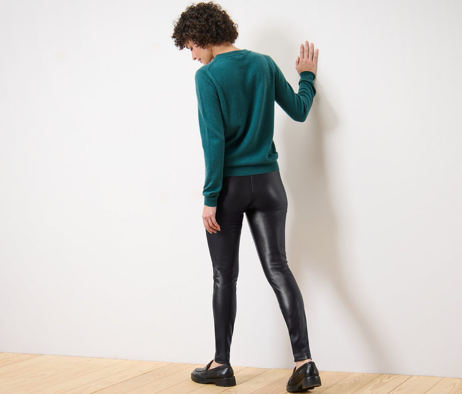 Frau steht mit dem Rücken zur Kamera und trägt Leggings in Lederoptik.