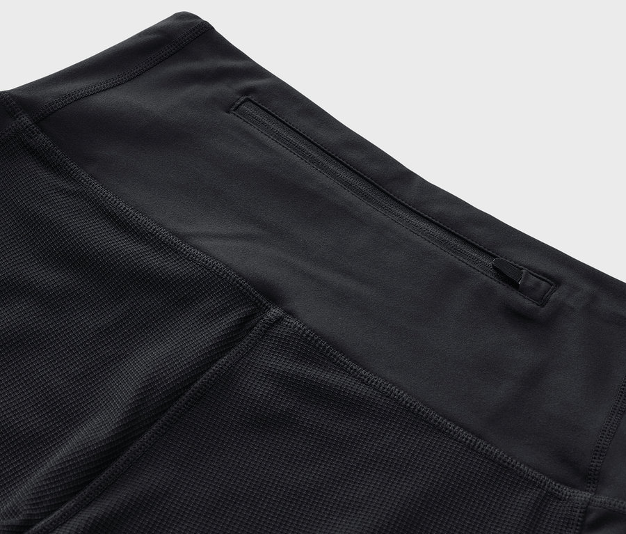 Detailaufnahme einer schwarzen 3/4-Trekking-Tight mit einer Reißverschlusstasche am Bund.