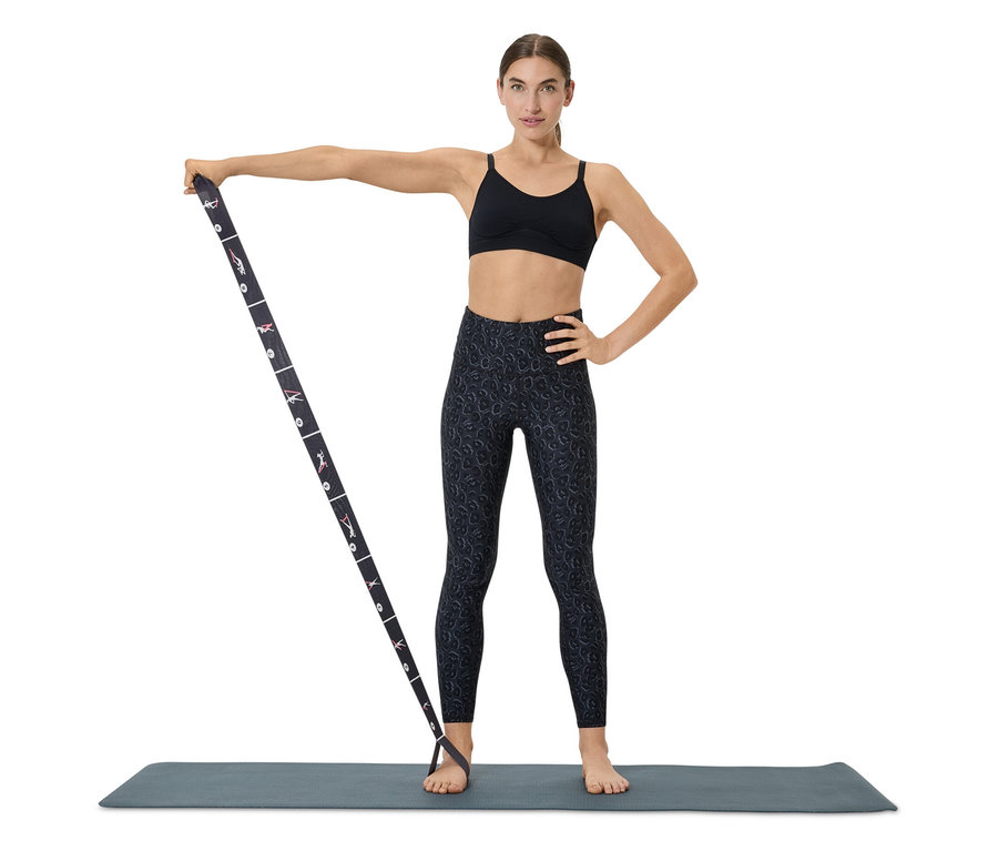 Frau trainiert mit Widerstandsband auf einer Matte.