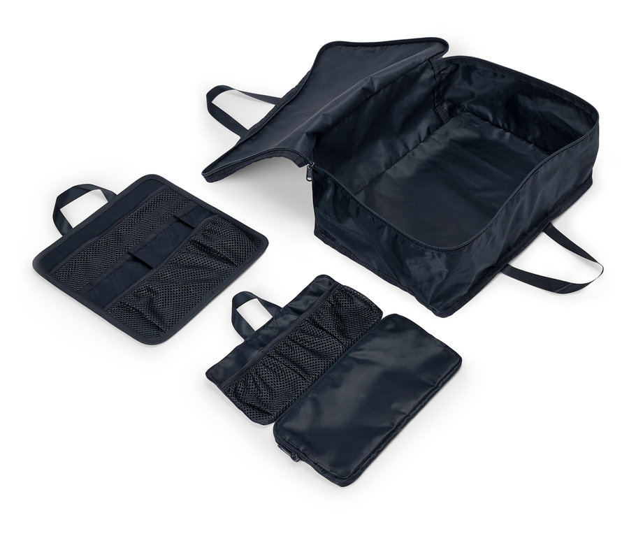 Drei marineblaue Stofftaschen mit Tragegriffen und Netzfächern liegen auf weißem Hintergrund. Eine Tasche ist geöffnet und zeigt das Innere.