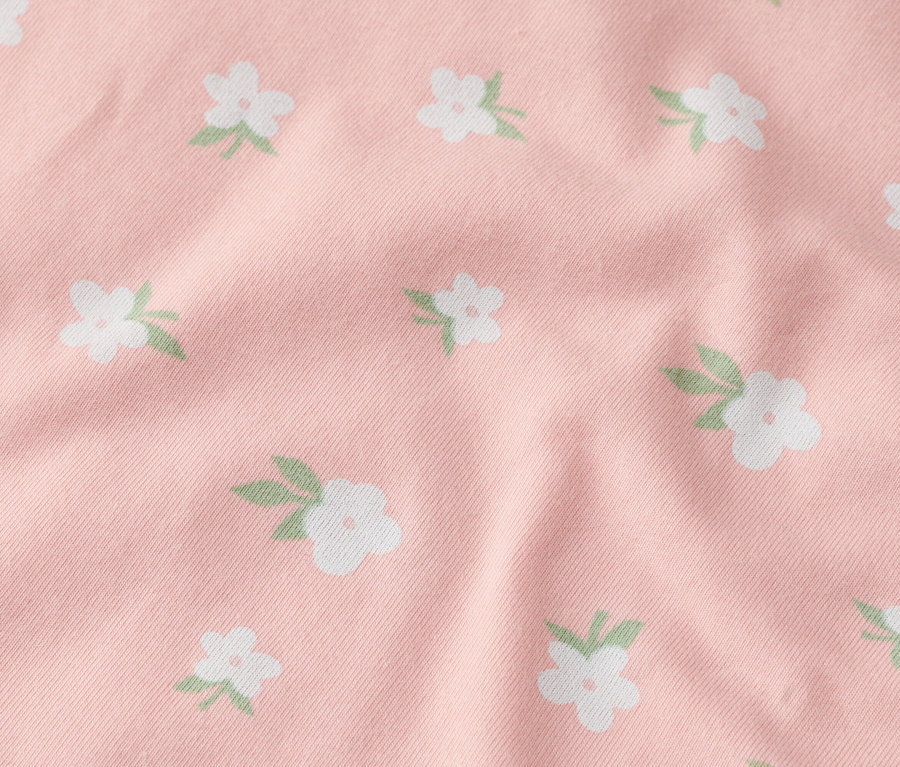 Nahaufnahme eines rosafarbenen Stoffes mit weißen Blüten.