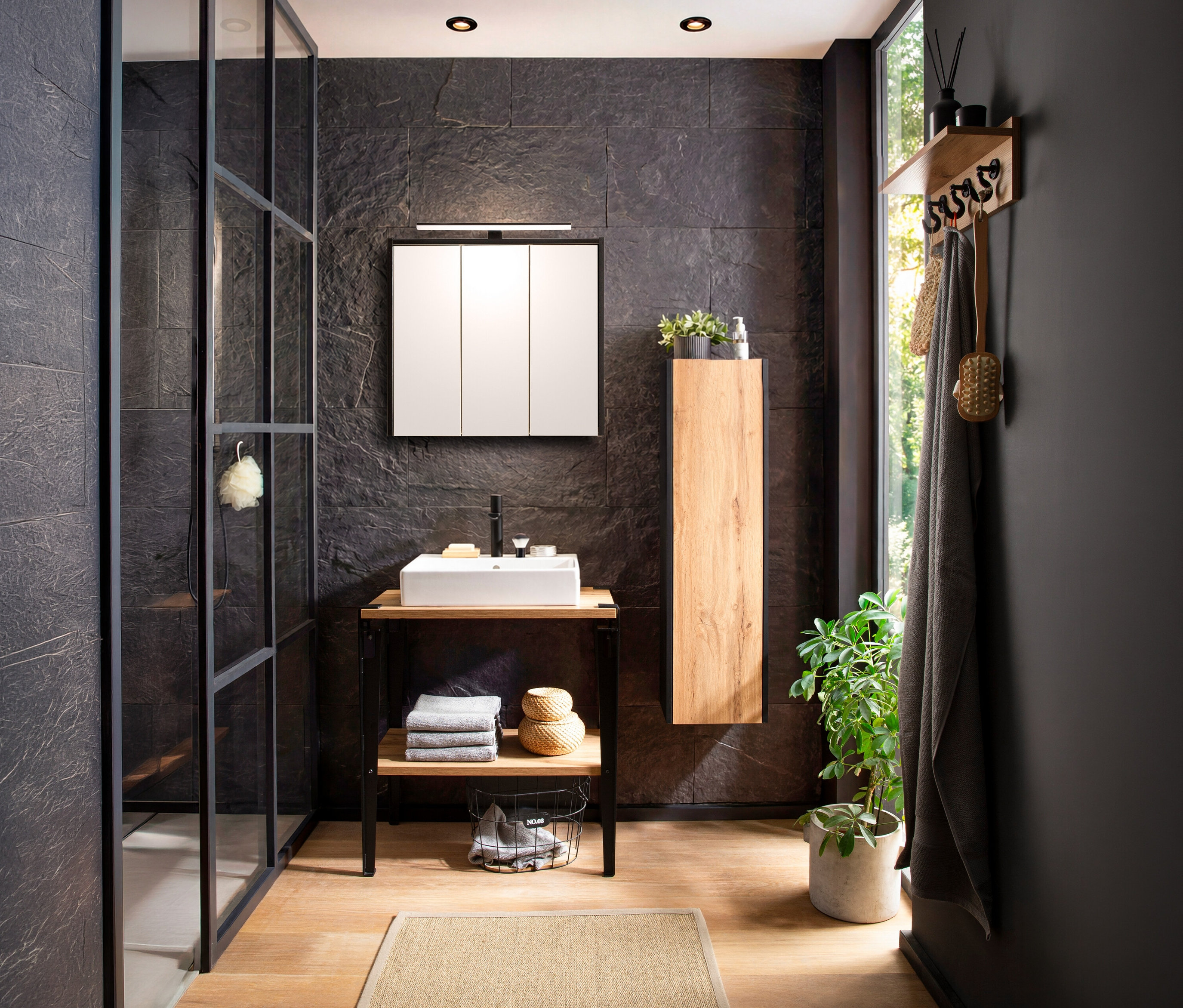 Badezimmer mit WS Waschtisch »Tonder« im Dekor Eiche Landhaus und WS Highboard »Tonder« im Dekor Eiche Landhaus neben einem Fenster.