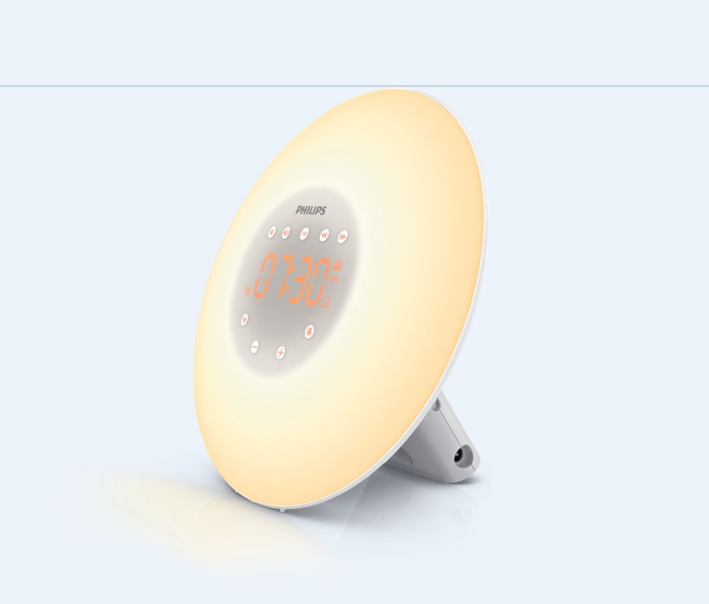 Philips-Wake-up-Light-Lichtwecker auf hellem Hintergrund. Auf dem runden Display leuchtet die Uhrzeit 07:30.