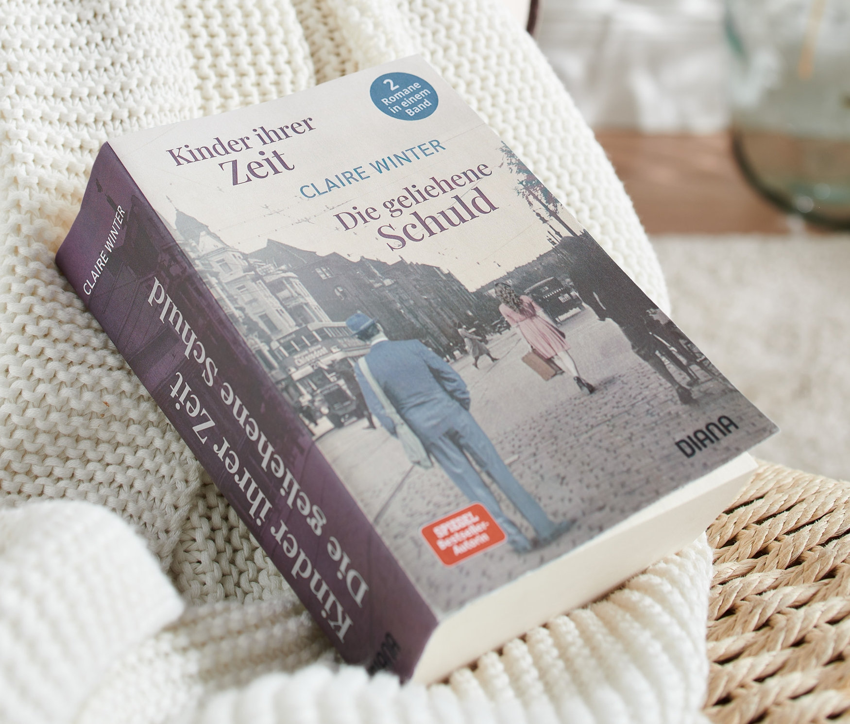 Der Doppelroman »Kinder ihrer Zeit« und »Die geliehene Schuld« liegt auf einer weißen Strickdecke.