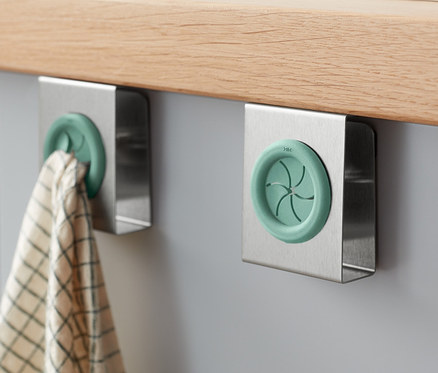 Zwei Geschirrtuchhalter sind an einem grauen Schrank unter einer Holzplatte befestigt.