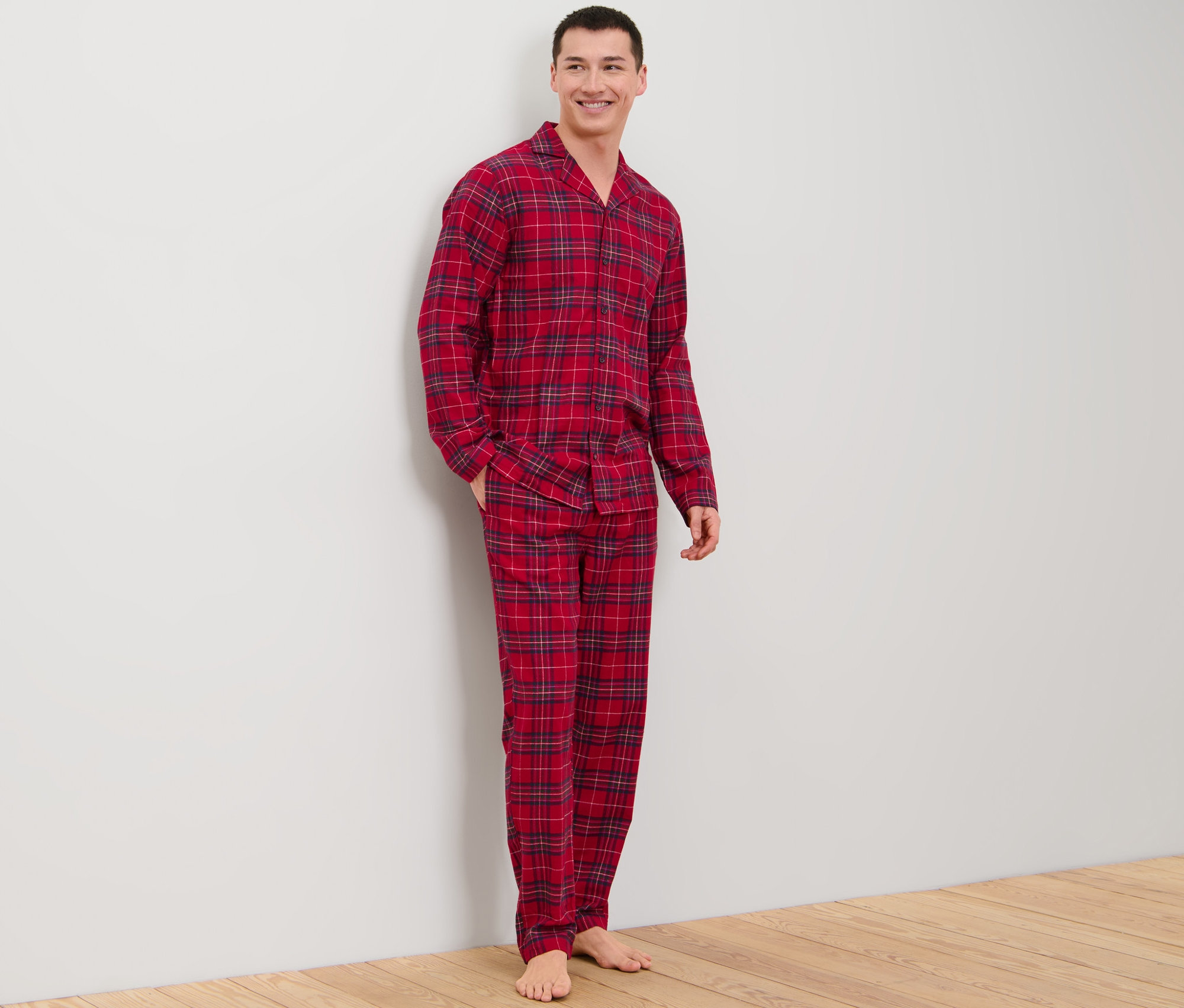 Ein Mann steht und trägt einen Flanell-Pyjama.