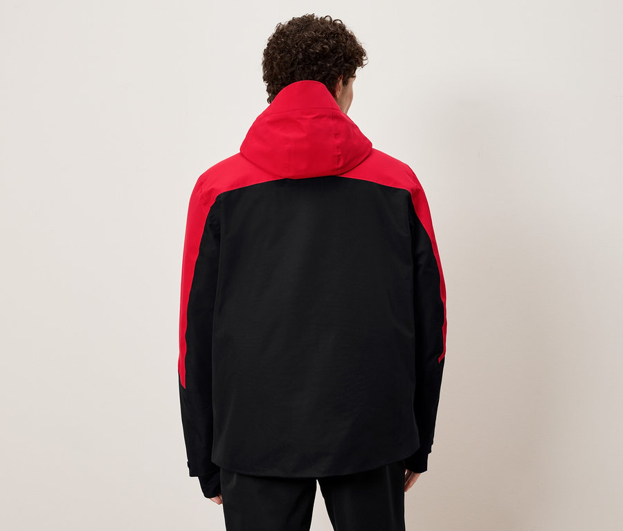 Mann von hinten trägt eine schwarz-rote Jacke mit Kapuze.