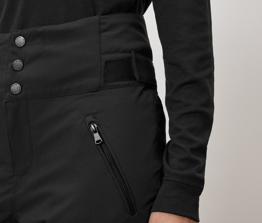 Schwarze Hose mit hohem Bund, drei Knöpfen und Reißverschlusstasche.