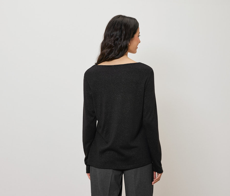 Rückansicht einer Frau mit dunklen Haaren, die ein glitzerndes schwarzes Langarmshirt trägt.