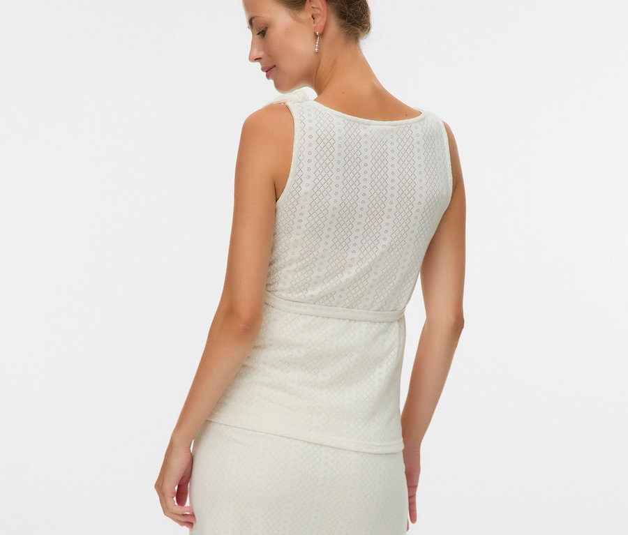 Frau von hinten in ärmellosem Oberteil und Rock mit Muster.