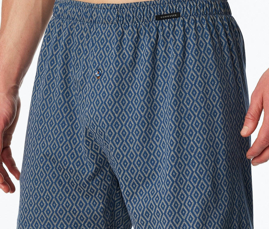 Mann trägt blaue Boxershorts mit Rautenmuster.