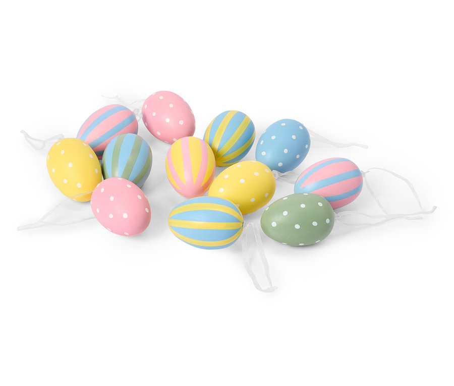 Mehrere pastellfarbene Ostereier mit Punkt- und Streifenmustern liegen auf einem weißen Hintergrund.