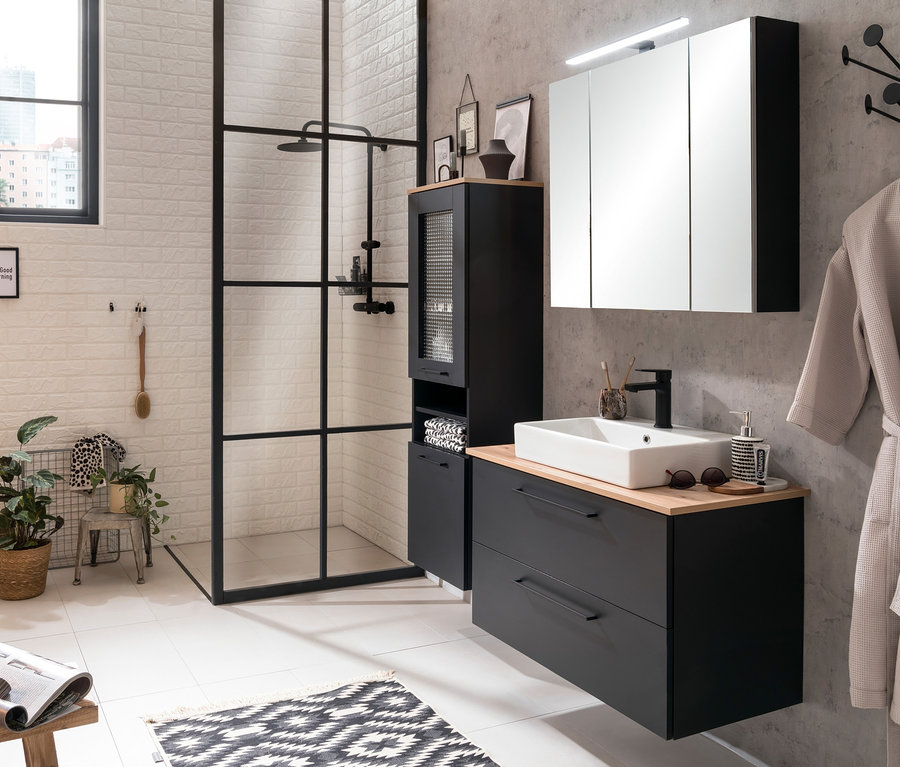 Badezimmer mit schwarzem Hochschrank »Malte« und Waschtisch »Malte«.