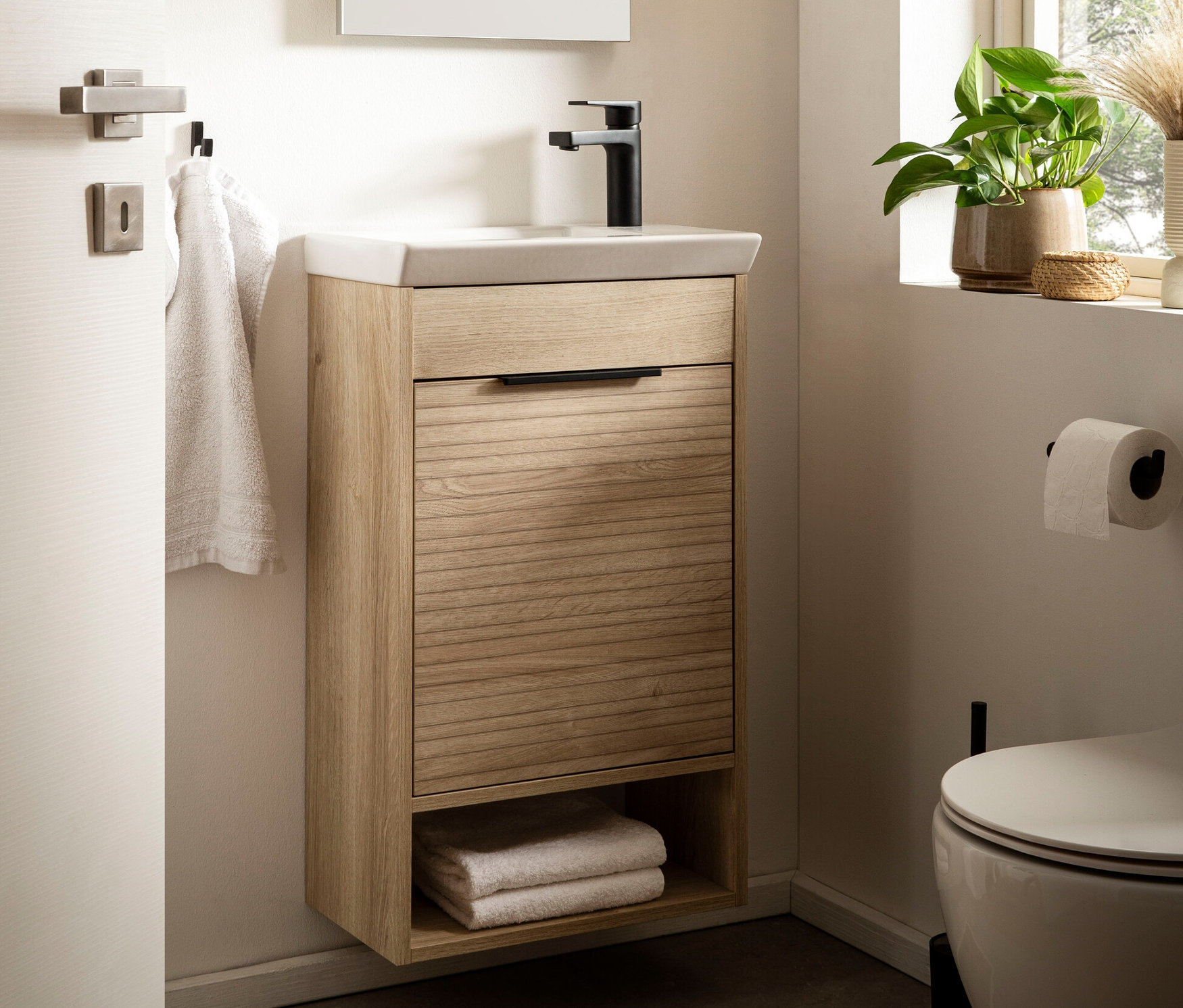 Badezimmer mit Mads Waschtisch mit Spiegel, neben Fenster.