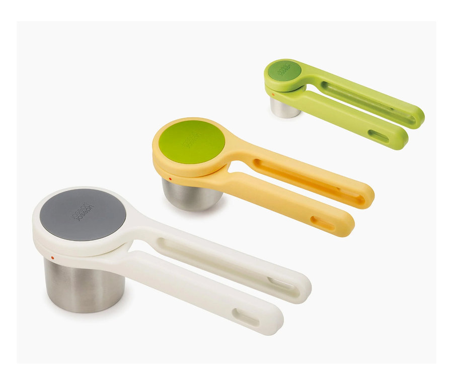 Drei Kartoffelstampfer in Weiß, Gelb und Grün stehen auf einer weißen Oberfläche.