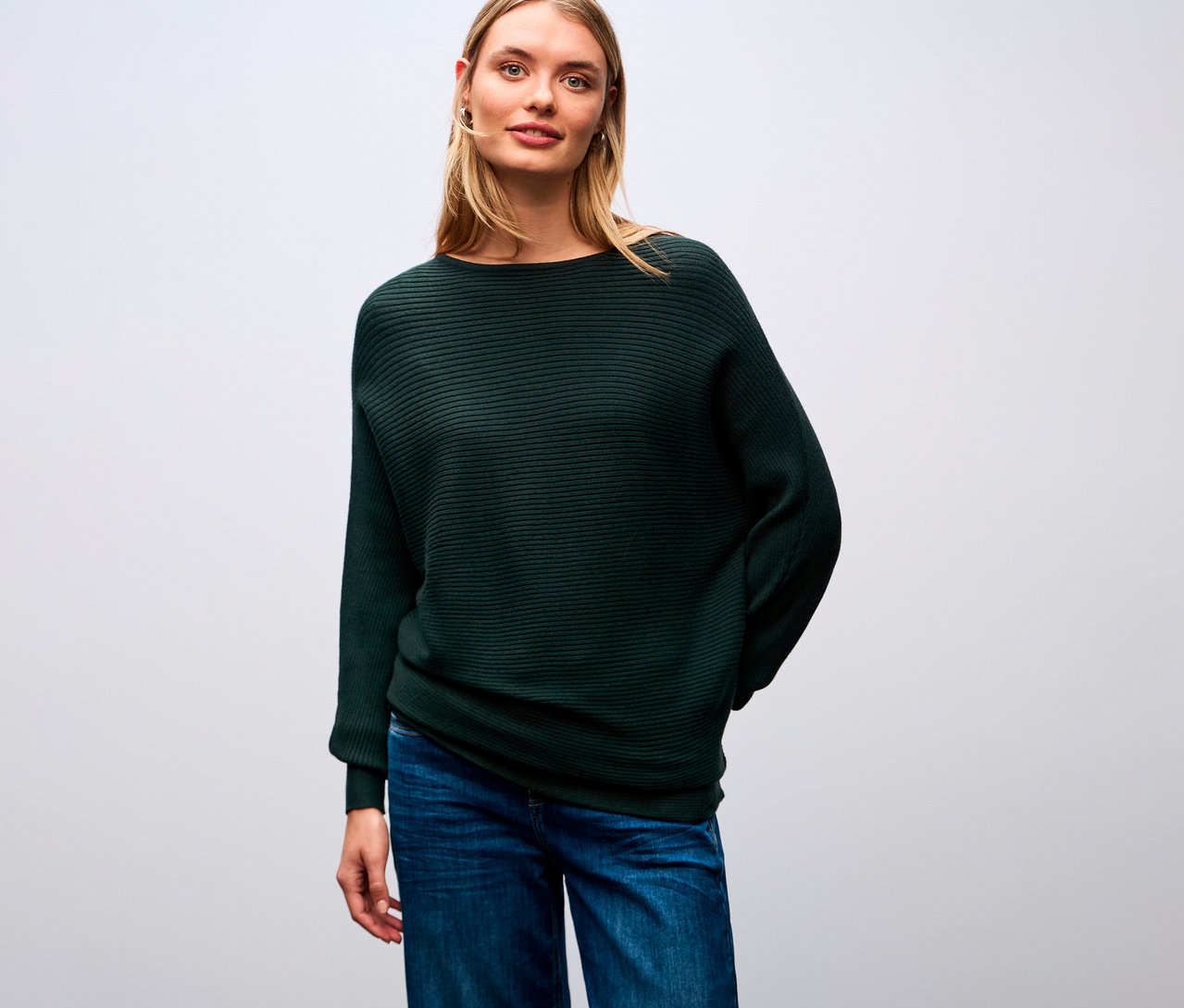 Frau trägt einen Street One Strukturpullover und Jeans.