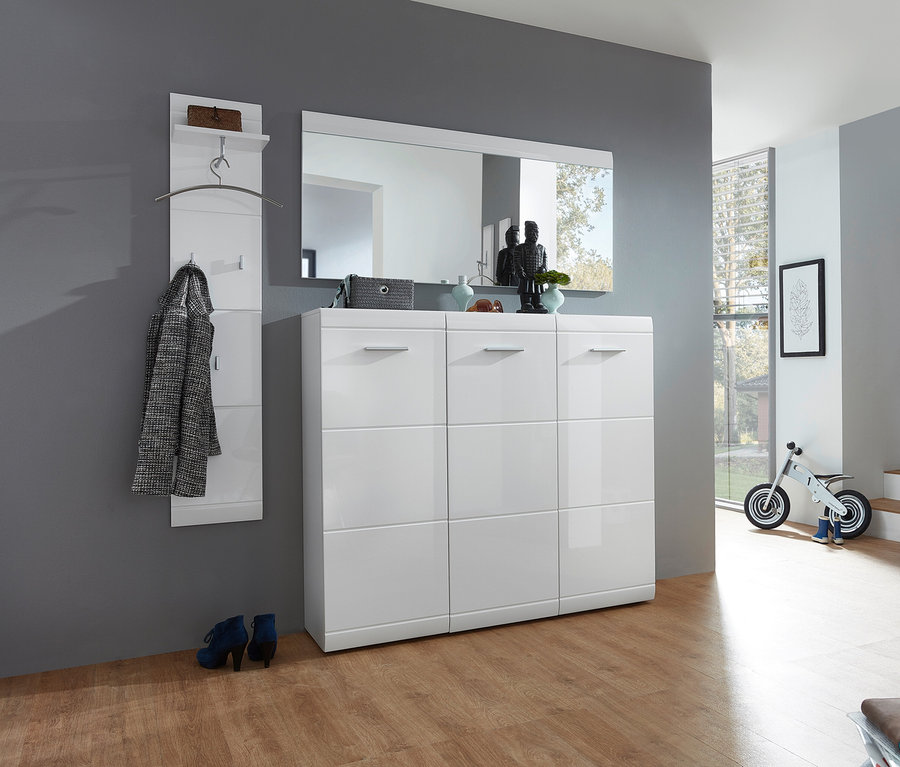 Flur mit weißem Schuhschrank, darüber ein großer Spiegel »ADANA« hängt. An der Wand daneben eine Garderobe mit Jacke.