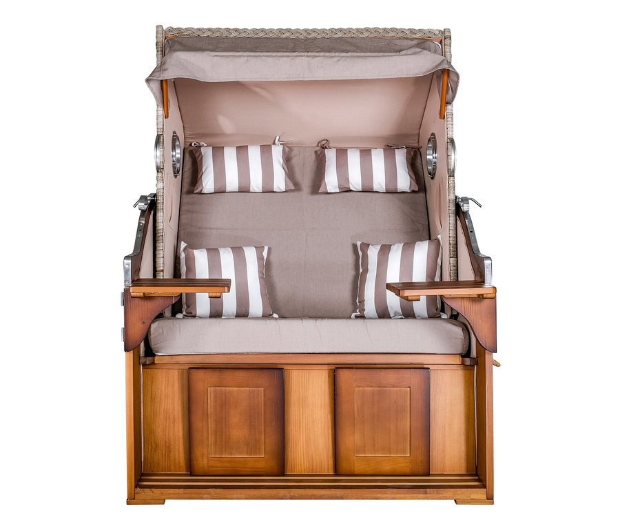 Ein Strandkorb mit braun-weiß gestreiften Kissen.