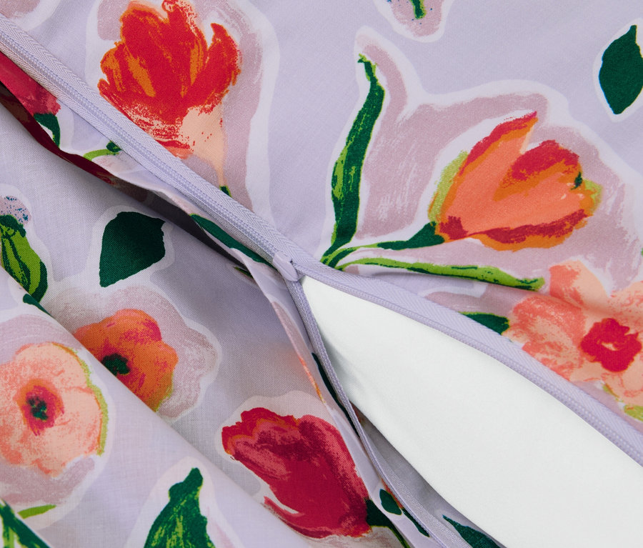 Detailansicht von lila Renforcé-Bettwäsche mit Blumenmuster und Reißverschluss.