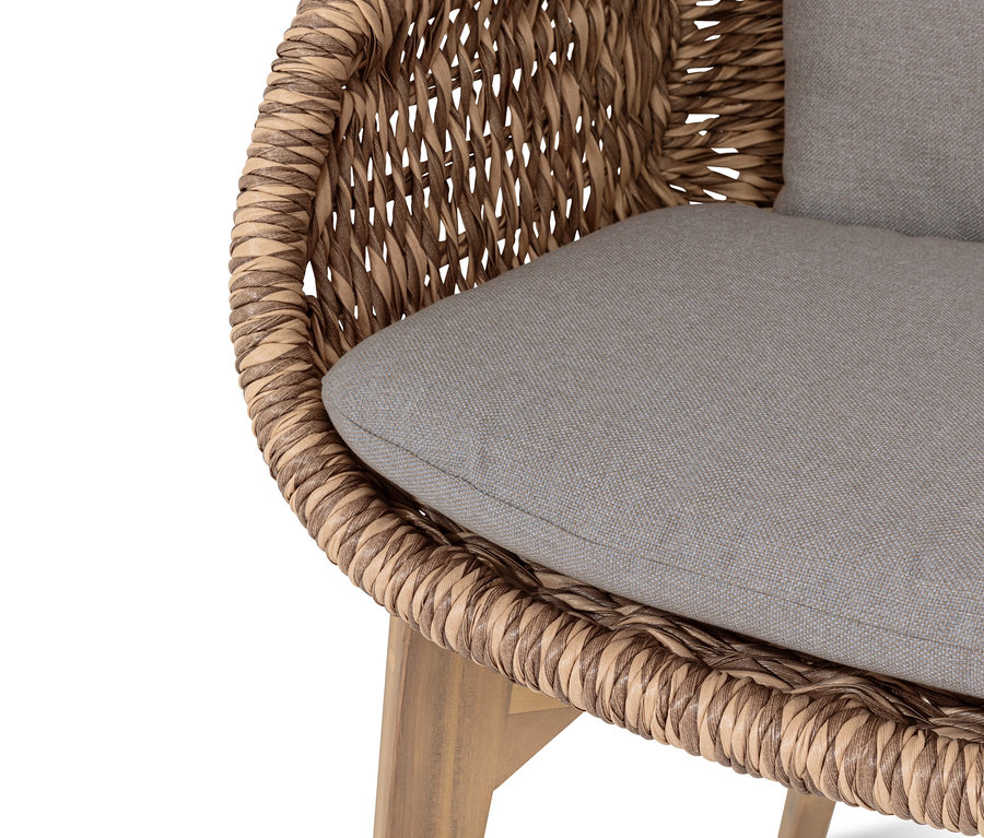 Detailansicht eines Premium-Schalenstuhls mit Polyrattan-Geflecht und grauem Sitzkissen.