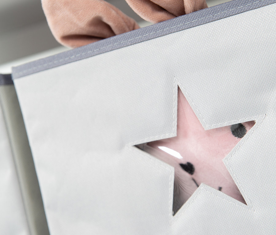 Detailansicht eines grauen Stoff-Aufbewahrungsbehälters mit Sternausschnitt und rosa Hasenohren.