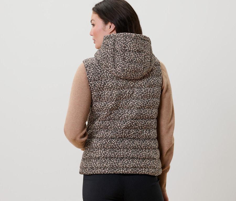 Frau von hinten trägt eine bedruckte Steppweste mit Kapuze.