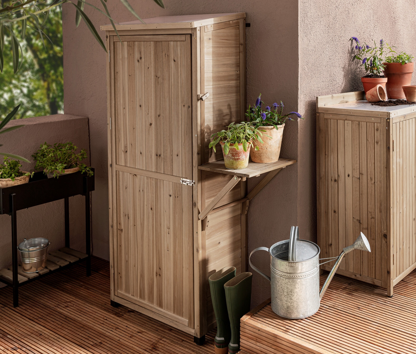 Zwei Gartenschränke »Tinus«, einer groß mit hochklappbarem Seitenregal und einer klein, sowie eine Pflanz-Konsole »Elin« auf einer Holzterrasse.